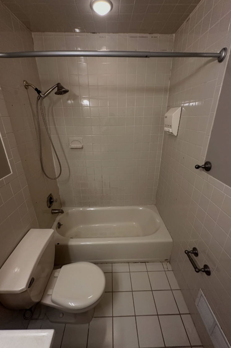 Dated white tile tub and shower before bathroom remodel in Parlin, NJ